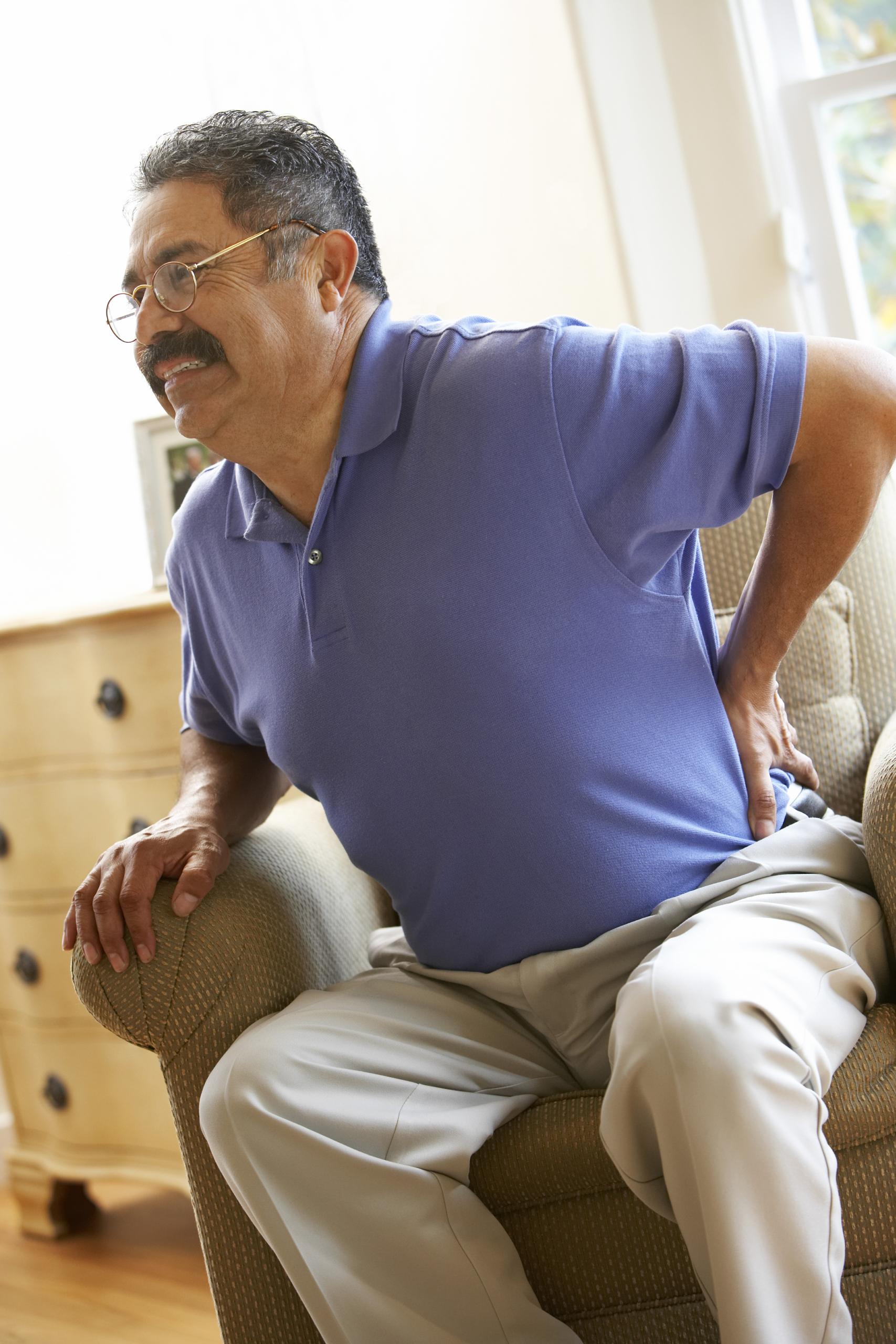 a man suffering from severe sciatica sitting on chair 